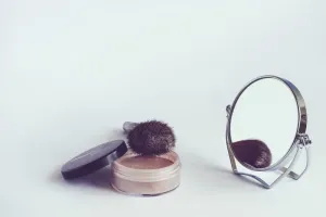 Elegancka szklana butelka kosmetyku na marmurowym blacie w otoczeniu eukaliptusa, podkreślająca świeżość i pielęgnację.